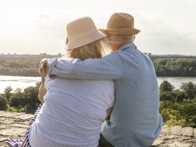 Man and woman sitting on a hilltop and discussing how common hearing loss is