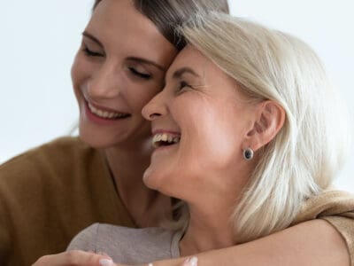 Daughter embraces her hearing-impaired mother after listening to her explain how to support her hearing loss