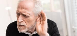 elderly man experiencing early warning signs of hearing loss