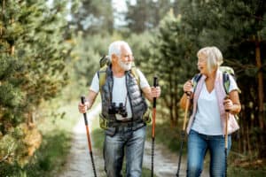 Happy senior couple wearing best value hearing aids hiking.