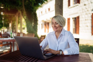 Woman smiling while taking a free online hearing test outdoors
