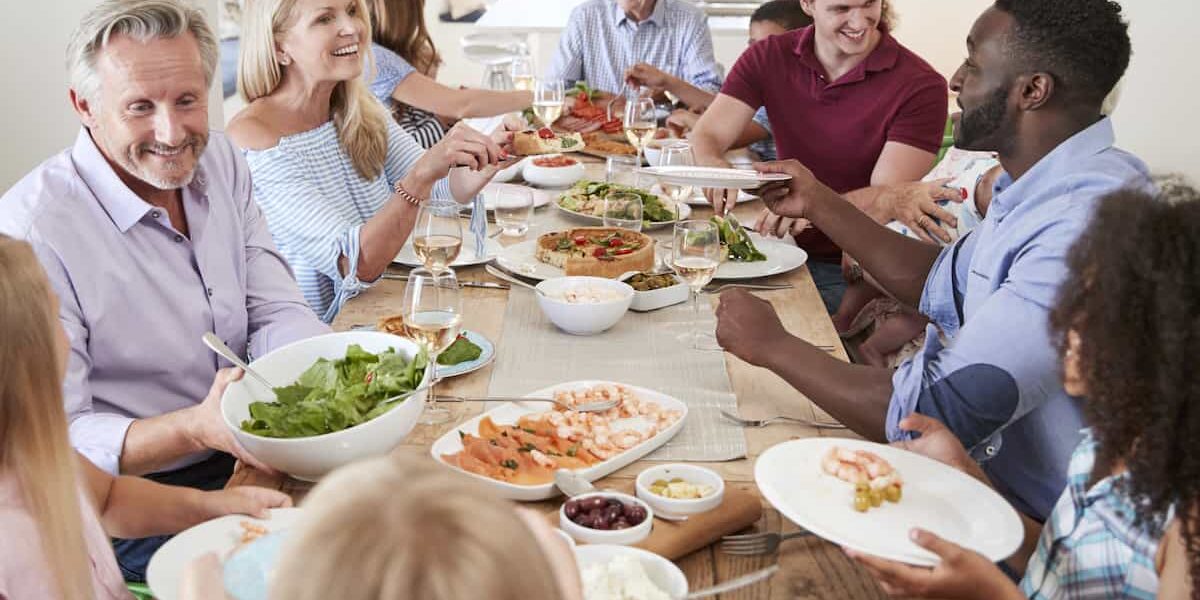 group of people around a dining table having a healthy meal discussing food and hearing health