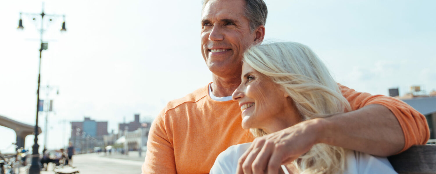 Happy senior couple spending time at the beach. Concepts about love,seniority and people. Both have hearing aid comfort