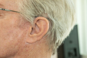 Senior man wearing a behind-the-ear hearing aid