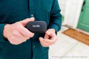 Man holding Lexie hearing aids. The hearing aids with a host of quality hearing aid features.