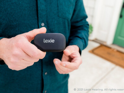 Man holding Lexie hearing aids. The hearing aids with a host of quality hearing aid features.